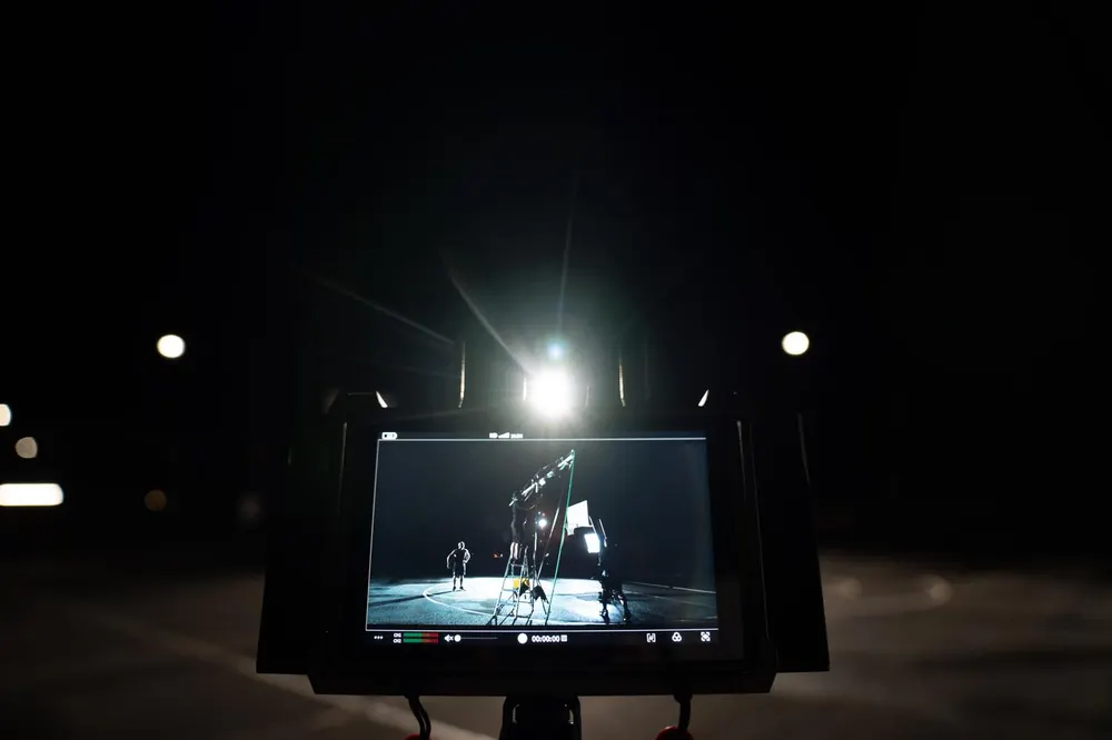 A single film light cutting through rain on a night shoot